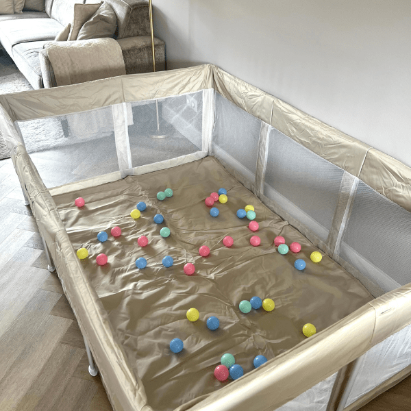 Peuter speelt veilig in een grondbox terwijl hij leert kruipen